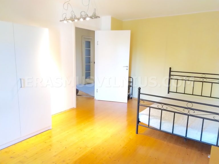 Détail de la chambre montrant la table de chevet et la lampe dans le logement étudiant