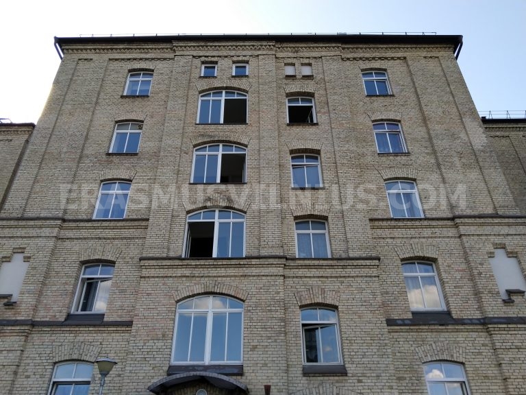 Vue estivale depuis la fenêtre de la chambre — toits de la vieille ville de Vilnius