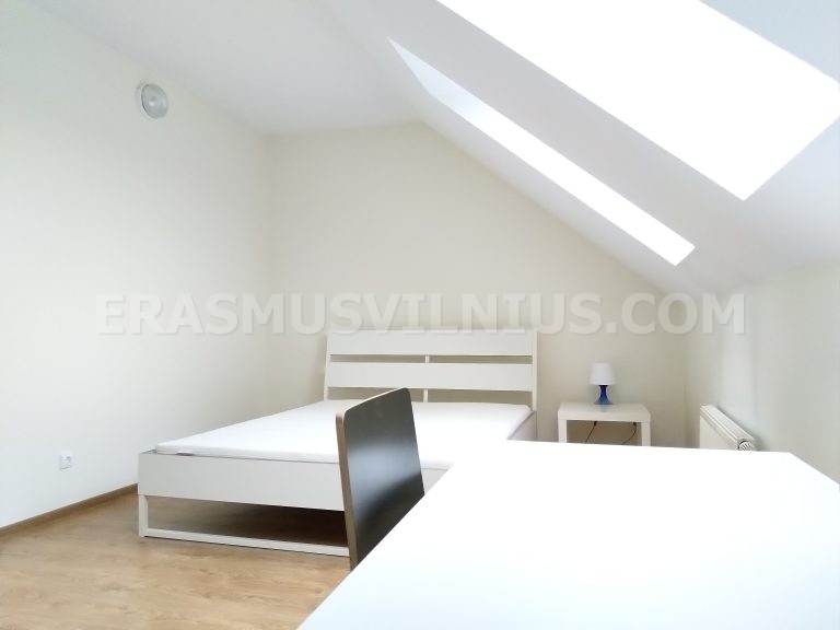 Intérieur de chambre étudiante avec armoire et espace de travail