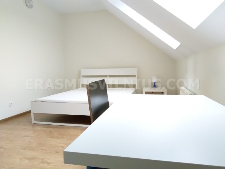 Détail de la chambre montrant le miroir et l'espace chevet dans l'appartement rénové